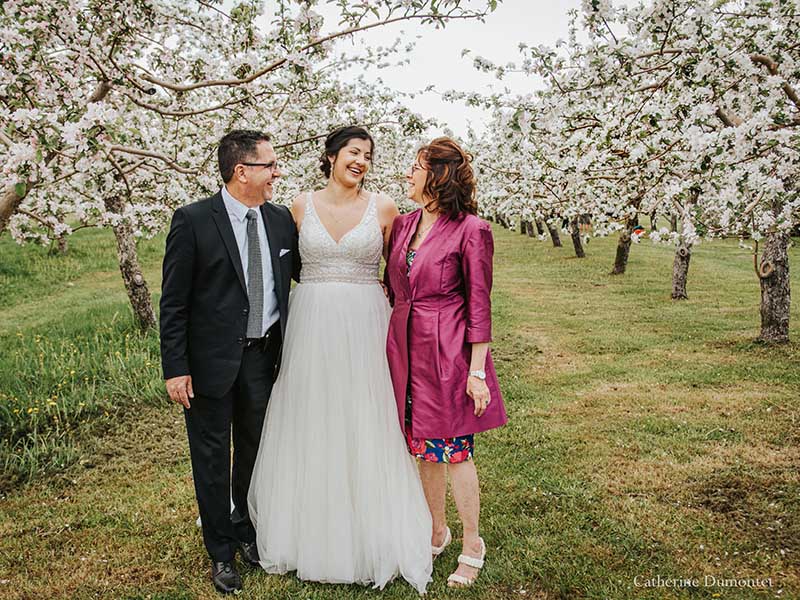 la mariée avec ses parents pendant la floraison du verger