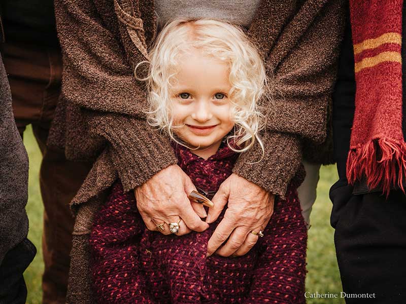 Petite fille entourée des mains de sa grand-maman